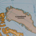 Drapeau danois flottant au Groenland, illustrant les arguments en faveur du maintien dans le Royaume du Danemark pour la stabilité et la sécurité.