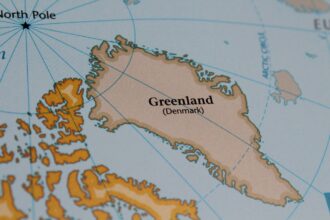 Drapeau danois flottant au Groenland, illustrant les arguments en faveur du maintien dans le Royaume du Danemark pour la stabilité et la sécurité.