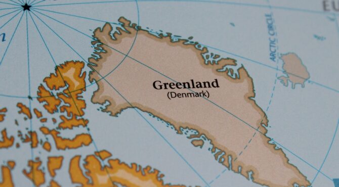 Drapeau danois flottant au Groenland, illustrant les arguments en faveur du maintien dans le Royaume du Danemark pour la stabilité et la sécurité.