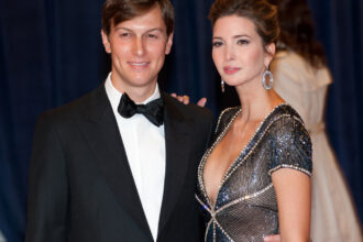 Portrait de Jared Kushner en costume, debout dans un décor institutionnel, illustrant son rôle de conseiller influent et de stratège diplomatique.