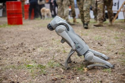 Robot militaire autonome équipé de capteurs et d’intelligence artificielle sur un terrain de combat futuriste.