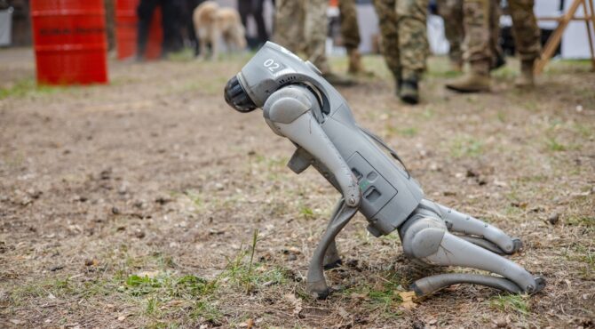 Robot militaire autonome équipé de capteurs et d’intelligence artificielle sur un terrain de combat futuriste.