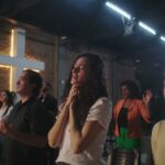 Chrétiens priant dans une église endommagée, symbole de la persécution des chrétiens dans le monde.