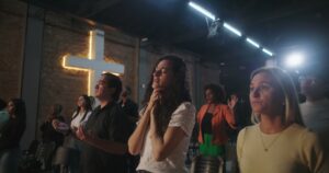 Chrétiens priant dans une église endommagée, symbole de la persécution des chrétiens dans le monde.