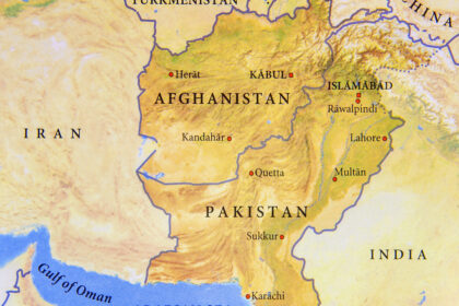 Paysage aride du Baloutchistan avec montagnes et villages isolés, illustrant l’immensité et l’isolement de cette région stratégique.