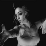 Photographie en noir et blanc de Mélanie Paolettoni dans un mouvement de danse, silhouette fluide et expressive, incarnant douceur, force et résilience.