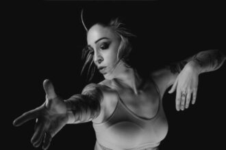 Photographie en noir et blanc de Mélanie Paolettoni dans un mouvement de danse, silhouette fluide et expressive, incarnant douceur, force et résilience.