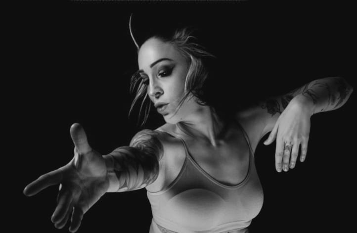 Photographie en noir et blanc de Mélanie Paolettoni dans un mouvement de danse, silhouette fluide et expressive, incarnant douceur, force et résilience.