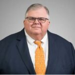 Portrait d’Agustín Carstens, en costume sombre, posant avec sérieux dans un décor institutionnel. Son expression est calme et assurée, reflétant son rôle majeur dans la finance mondiale.