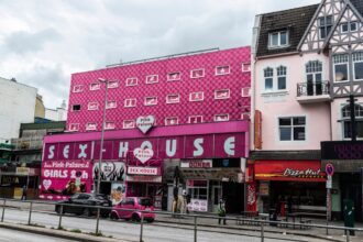 Une photographie institutionnelle montrant la façade d’un bâtiment gouvernemental européen, symbole de l’autorité publique. L’image évoque la dimension juridique et politique du débat sur la prostitution féminine, dans une atmosphère sobre et neutre, adaptée à une analyse comparative des législations nationales.