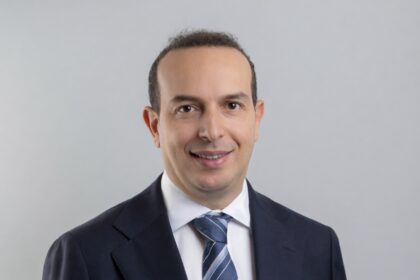 Portrait professionnel de Lamine Bougueroua, nouveau gérant dette émergente chez Carmignac, photographié en tenue formelle dans un environnement corporate. L’image met en avant une posture assurée et analytique, reflétant son expertise sur les marchés obligataires émergents. En arrière‑plan, un décor neutre ou un bureau moderne évoque un cadre institutionnel, renforçant l’idée de rigueur et de gestion active.