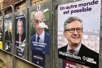 Portrait analytique et sobre de Jean‑Luc Mélenchon, en arrière‑plan un hémicycle flou symbolisant le débat politique français et les recompositions électorales.