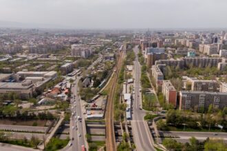 Autobus modernes au gaz naturel comprimé circulant dans les rues de Bichkek, illustrant la modernisation du transport public et la transition vers une mobilité plus propre.