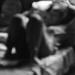 Travailleuse du sexe dans une rue éclairée la nuit, illustrant la précarité et les enjeux de sécurité liés au travail sexuel en France.