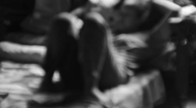 Travailleuse du sexe dans une rue éclairée la nuit, illustrant la précarité et les enjeux de sécurité liés au travail sexuel en France.