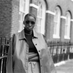 Un bureau sobre éclairé par une lumière rasante, avec des dossiers anonymisés, une carte du monde annotée et un ordinateur ouvert, symbolisant l’univers discret du renseignement international.