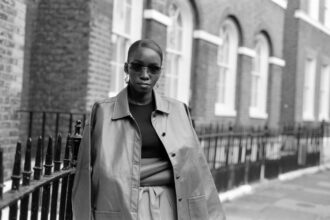 Un bureau sobre éclairé par une lumière rasante, avec des dossiers anonymisés, une carte du monde annotée et un ordinateur ouvert, symbolisant l’univers discret du renseignement international.