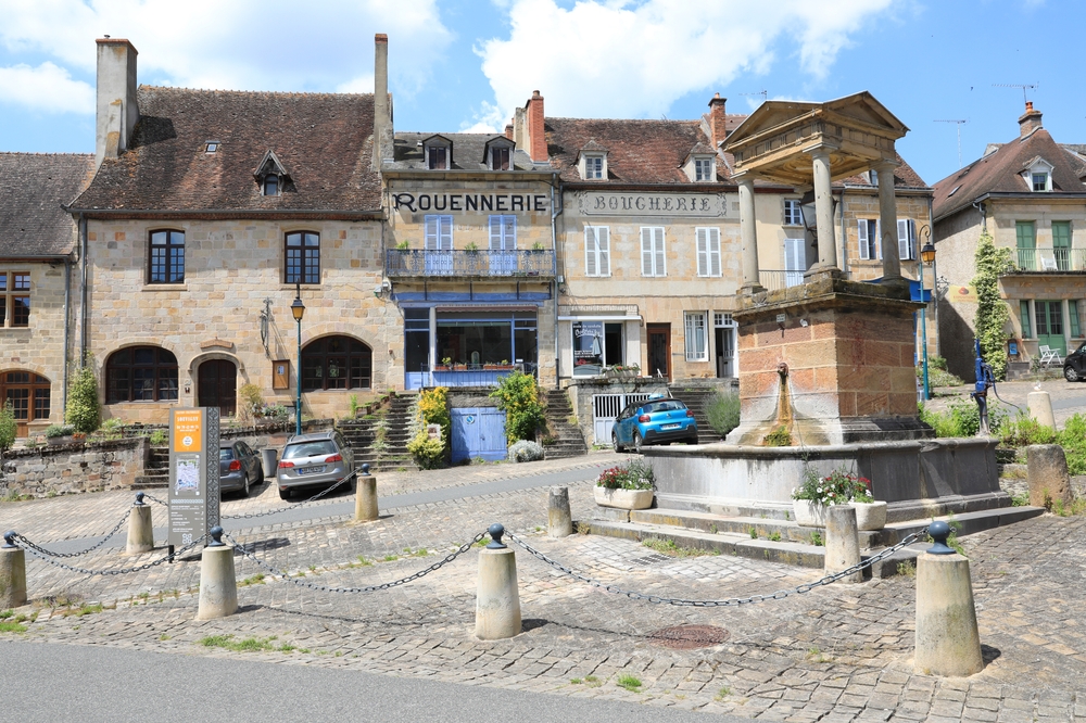 Paysage rural français avec champs, village et horizon boisé, symbolisant la vitalité des territoires et la transmission des savoir‑faire.