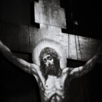 Image d’une église française au crépuscule, façade éclairée mais parvis désert, symbolisant un christianisme fragilisé. À l’arrière‑plan, silhouettes floues représentant les tensions entre héritage religieux, critiques culturelles et récupérations identitaires.