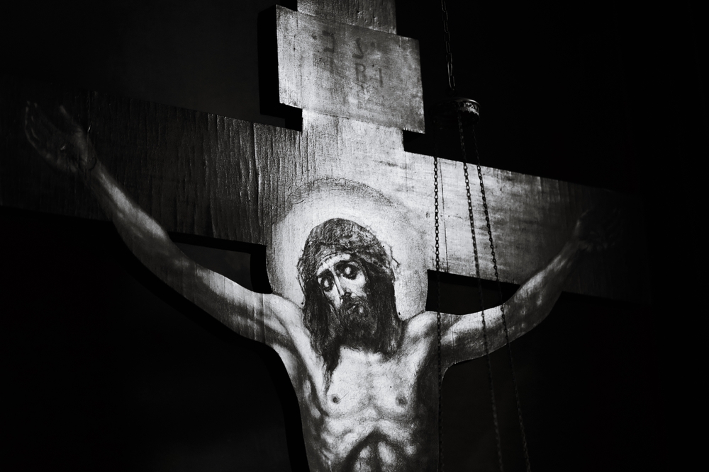 Image d’une église française au crépuscule, façade éclairée mais parvis désert, symbolisant un christianisme fragilisé. À l’arrière‑plan, silhouettes floues représentant les tensions entre héritage religieux, critiques culturelles et récupérations identitaires.