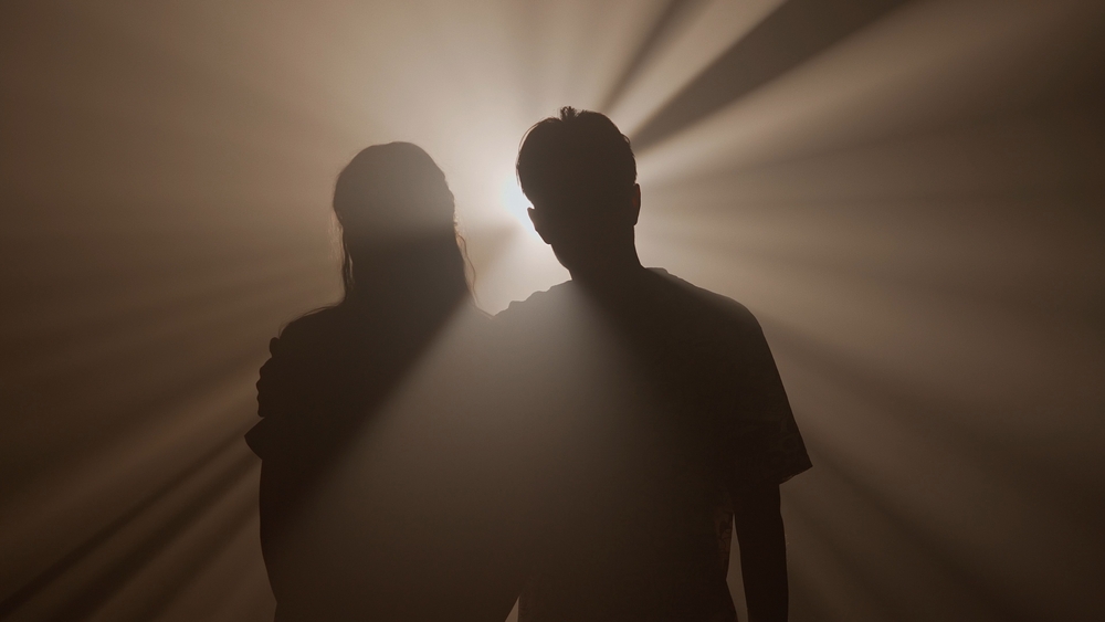 Silhouette d’un homme seul sous un réverbère dans une rue sombre, symbolisant l’ego face à ses ombres et la quête de lumière intérieure.