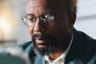 Une scène urbaine européenne en soirée, avec des silhouettes en discussion dans un café, symbolisant les réseaux diasporiques et les stratégies discrètes de recrutement menées par certains services de renseignement africains.