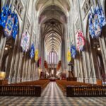 Jeune prêtre marchant dans une église vide, symbole du catholicisme français en recomposition entre déchristianisation et renouveau du sacerdoce.