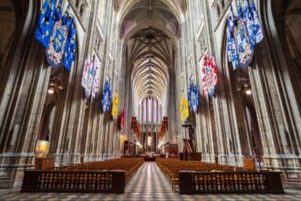 Jeune prêtre marchant dans une église vide, symbole du catholicisme français en recomposition entre déchristianisation et renouveau du sacerdoce.