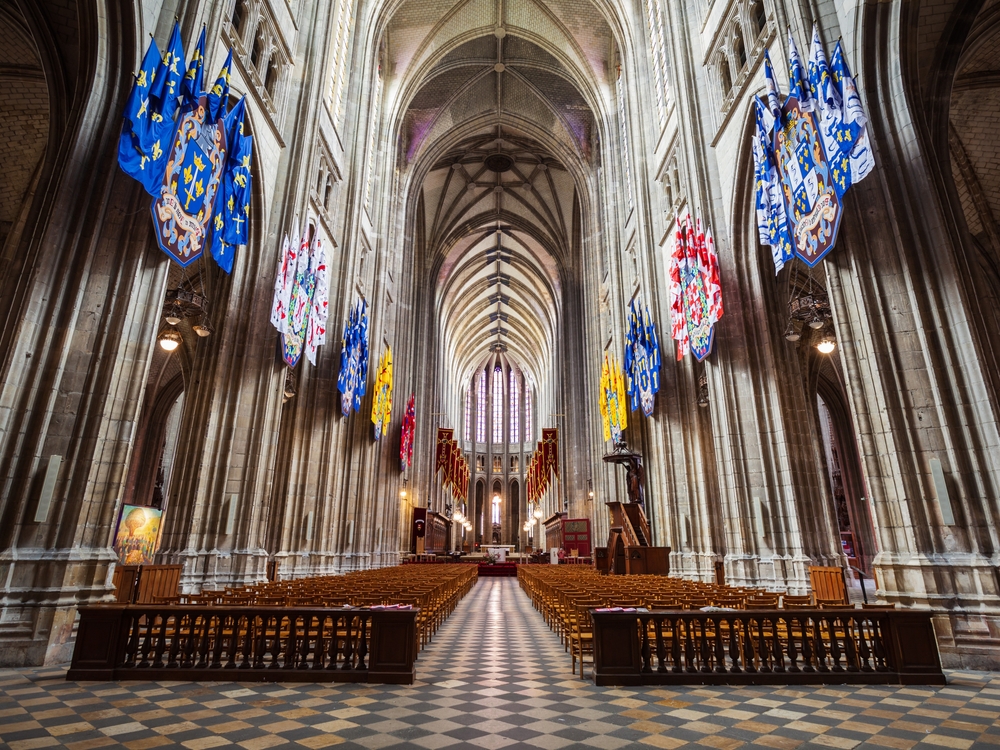 Jeune prêtre marchant dans une église vide, symbole du catholicisme français en recomposition entre déchristianisation et renouveau du sacerdoce.