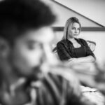 Couple à table, l’un dégustant un repas, l’autre optant pour un plat frugal, illustrant le Carême en couple, la sobriété alimentaire et la discipline spirituelle.