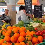 Photo de fruits et légumes en supermarché illustrant la hausse des prix et les marges de la grande distribution.