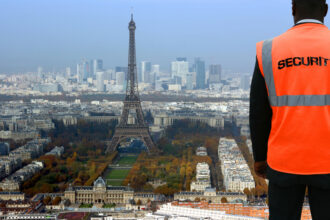 Vue nocturne de Paris avec la silhouette de bâtiments diplomatiques et des lumières urbaines, suggérant une atmosphère de surveillance, de discrétion et d’activités de renseignement.