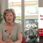 Portrait en lumière douce d’une femme d’une cinquantaine d’années, sereine, assise près d’une fenêtre. Le décor est épuré, évoquant la réflexion et la transmission. L’image suggère la maturité, la confiance et la quête d’informations fiables sur la ménopause.