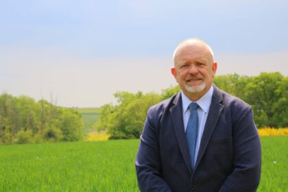 Portrait d’Éric dans un cadre rural, entouré d’animaux, reflétant sa bienveillance, son lien profond avec le vivant et son engagement pour la ruralité.