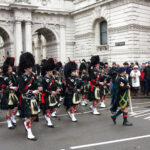 Défilé des Atholl Highlanders devant Blair Castle, avec soldats en tenue traditionnelle, drapeaux et cornemuses dans un cadre historique écossais.