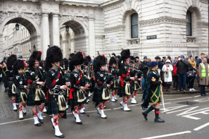 Défilé des Atholl Highlanders devant Blair Castle, avec soldats en tenue traditionnelle, drapeaux et cornemuses dans un cadre historique écossais.