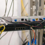 Illustration d’un routeur réseau entouré d’icônes de cybersécurité, symbolisant la décision de la FCC de restreindre les équipements étrangers.