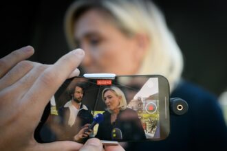 Une carte de France stylisée, traversée par une fissure lumineuse symbolisant la fracture démographique : zones rurales qui se vident, métropoles sous pression migratoire, et un bloc politique national en ascension. L’atmosphère est grave, presque crépusculaire, évoquant une mutation profonde du pays.