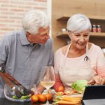 Portrait d’une personne âgée assise près d’une fenêtre, éclairée par une lumière douce, illustrant la solitude et l’invisibilité sociale liée au vieillissement.