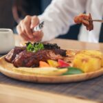 Un éleveur français guidant son troupeau dans une prairie, illustrant la qualité, le savoir-faire et l’engagement de la filière bovine nationale.