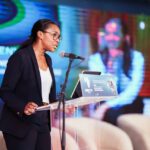 Manying Garandeau intervenant lors des PROCOM 2026 à Libreville, au Gabon, devant un public de professionnels et de représentants institutionnels.