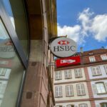 Un conseiller financier échange avec un client autour de documents patrimoniaux, illustrant le choix entre banque, CGP et fintech pour gérer son patrimoine