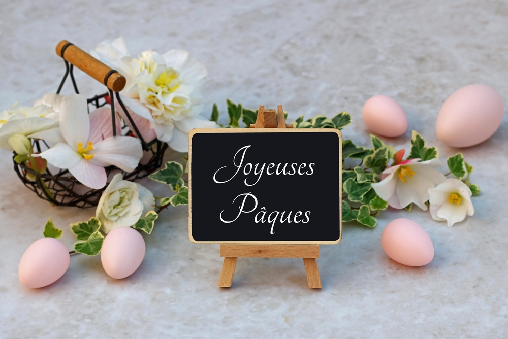 Enfants participant à une chasse aux œufs de Pâques dans un jardin en France, symbole des traditions pascales françaises.