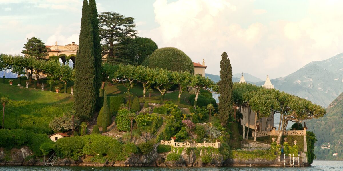 Vue panoramique de la Villa del Balbianello dominant le lac de Côme, entourée de jardins en terrasses et du paysage montagneux de la Tremezzina.