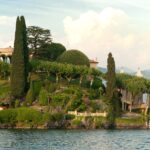 Vue panoramique de la Villa del Balbianello dominant le lac de Côme, entourée de jardins en terrasses et du paysage montagneux de la Tremezzina.