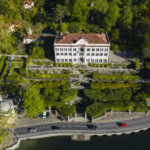 Vue de la Villa Carlotta entourée de jardins luxuriants, avec le lac de Côme en arrière‑plan et les terrasses fleuries qui mènent au musée.