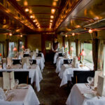 Intérieur raffiné d’un train de luxe Train de Prestige, avec boiseries élégantes, fauteuils confortables et ambiance haut de gamme évoquant le voyage d’exception.