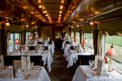 Intérieur raffiné d’un train de luxe Train de Prestige, avec boiseries élégantes, fauteuils confortables et ambiance haut de gamme évoquant le voyage d’exception.