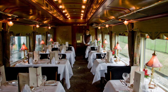 Intérieur raffiné d’un train de luxe Train de Prestige, avec boiseries élégantes, fauteuils confortables et ambiance haut de gamme évoquant le voyage d’exception.