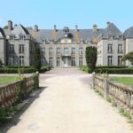 Vue d’un château français entouré de jardins, illustrant la tendance 2026 de la location de demeures historiques pour les vacances.